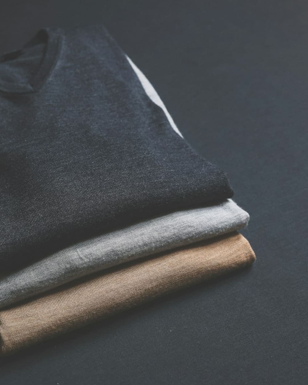 Folded tees in charcoal, grey and sand