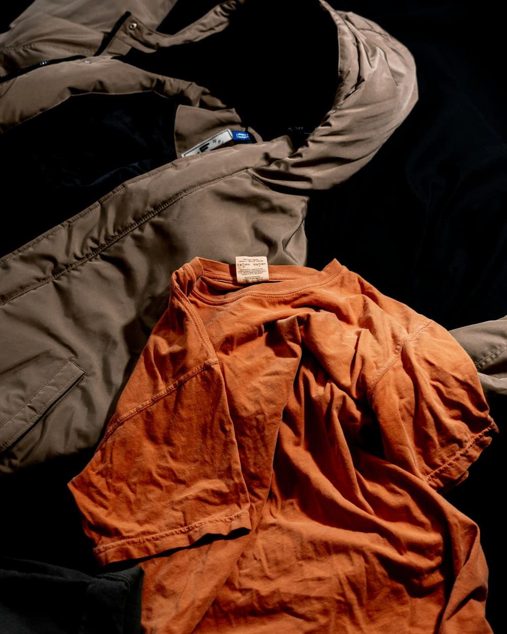 Orange parka crumpled on a dark surface